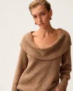 Plano médio da modelo com suéter tricot canelado gola degagê destacando as clavículas e textura canelada.