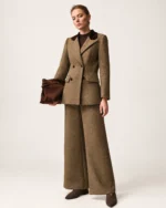 Modelo vestindo conjunto blazer alfaiataria bicolor marrom café com calça pantalona e clutch em estúdio mineral