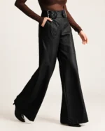 Calça pantalona em couro preto em movimento de caminhada