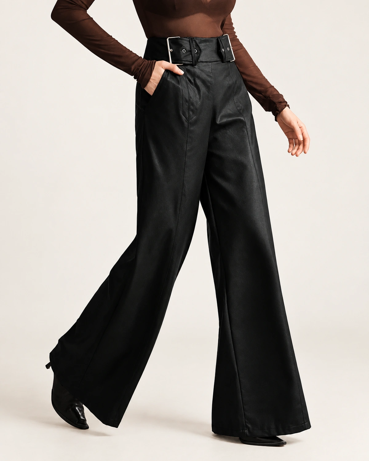 Calça pantalona em couro preto em movimento de caminhada