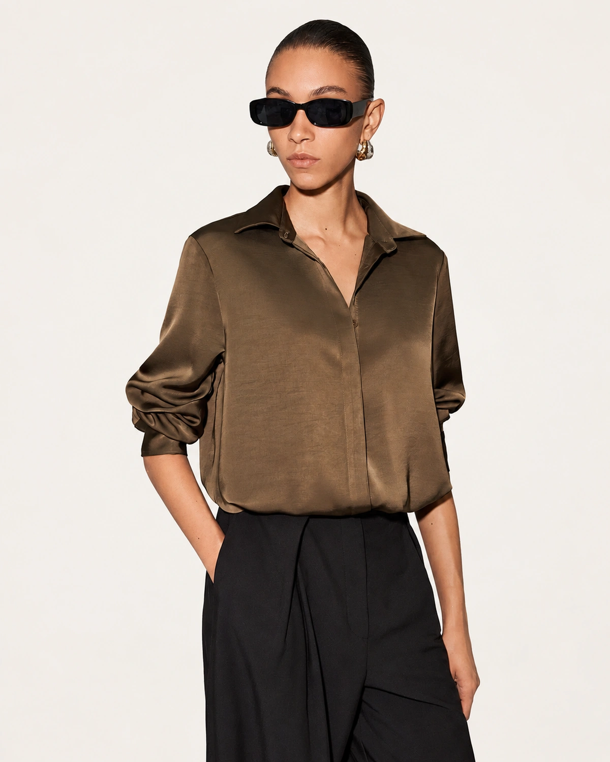 Enquadramento frontal em plano médio da camisa feminina de seda acetinada na cor café com fechamento embutido em estúdio mineral.