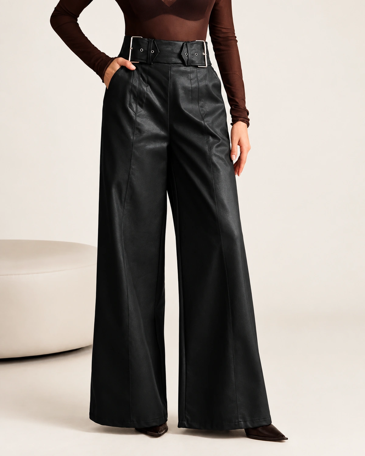 Detalhe frontal do cós alto e cinto da calça pantalona feminina em couro preto