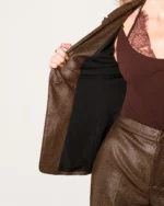 Plano aproximado do blazer alfaiataria bronze metalizado aberto exibindo o forro acetinado e a rica textura do tecido.
