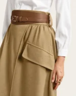 Modelo vestindo Saia Midi Evasê Alfaiataria com Cinto cor cáqui no estúdio mineral Peaker.