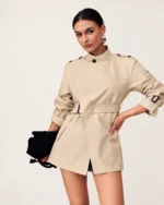 Modelo vestindo Trench Coat Alfaiataria com Cinto e Gola Alta Cáqui no estúdio mineral Peaker.