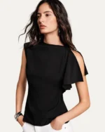 Modelo vestindo blusa assimétrica em crepe fluido preta com calça branca em estúdio mineral