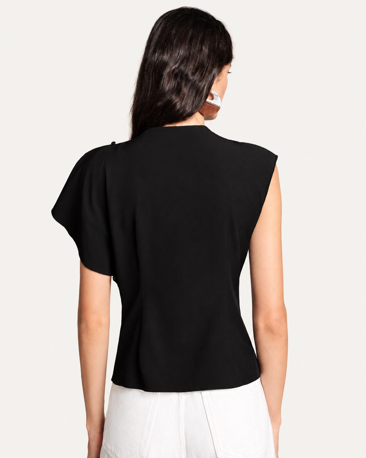 Vista posterior da blusa assimétrica preta exibindo corte das costas e manga capa