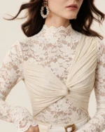 Blusa feminina em renda floral com nó frontal em estúdio mineral.