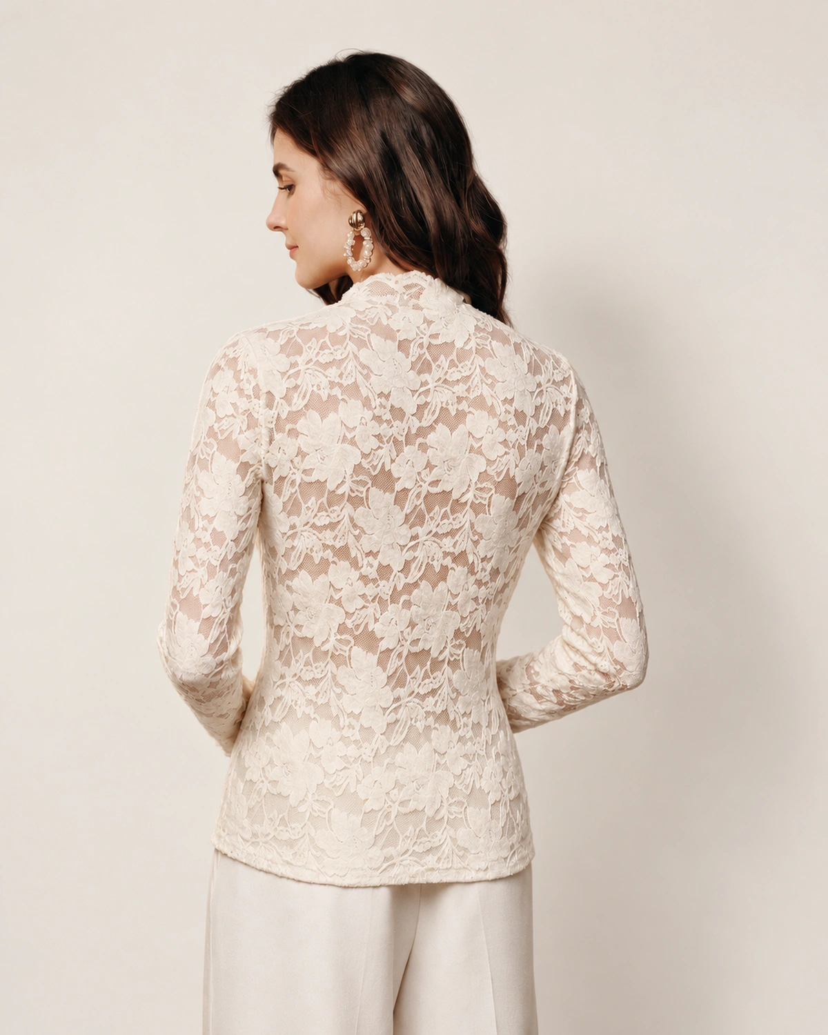 Blusa feminina em renda floral com nó frontal em estúdio mineral.
