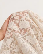 Blusa feminina em renda floral com nó frontal em estúdio mineral.