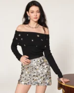 Plano americano da modelo vestindo blusa ombro a ombro preta em estúdio mineral