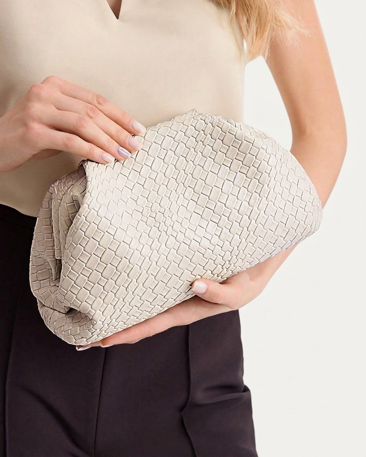 Bolsa clutch feminina drapeada em material sintético PU plissado na cor bege em estúdio mineral.