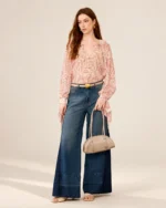 Plano de corpo inteiro da modelo com a bolsa meia-lua croco areia em estúdio mineral.