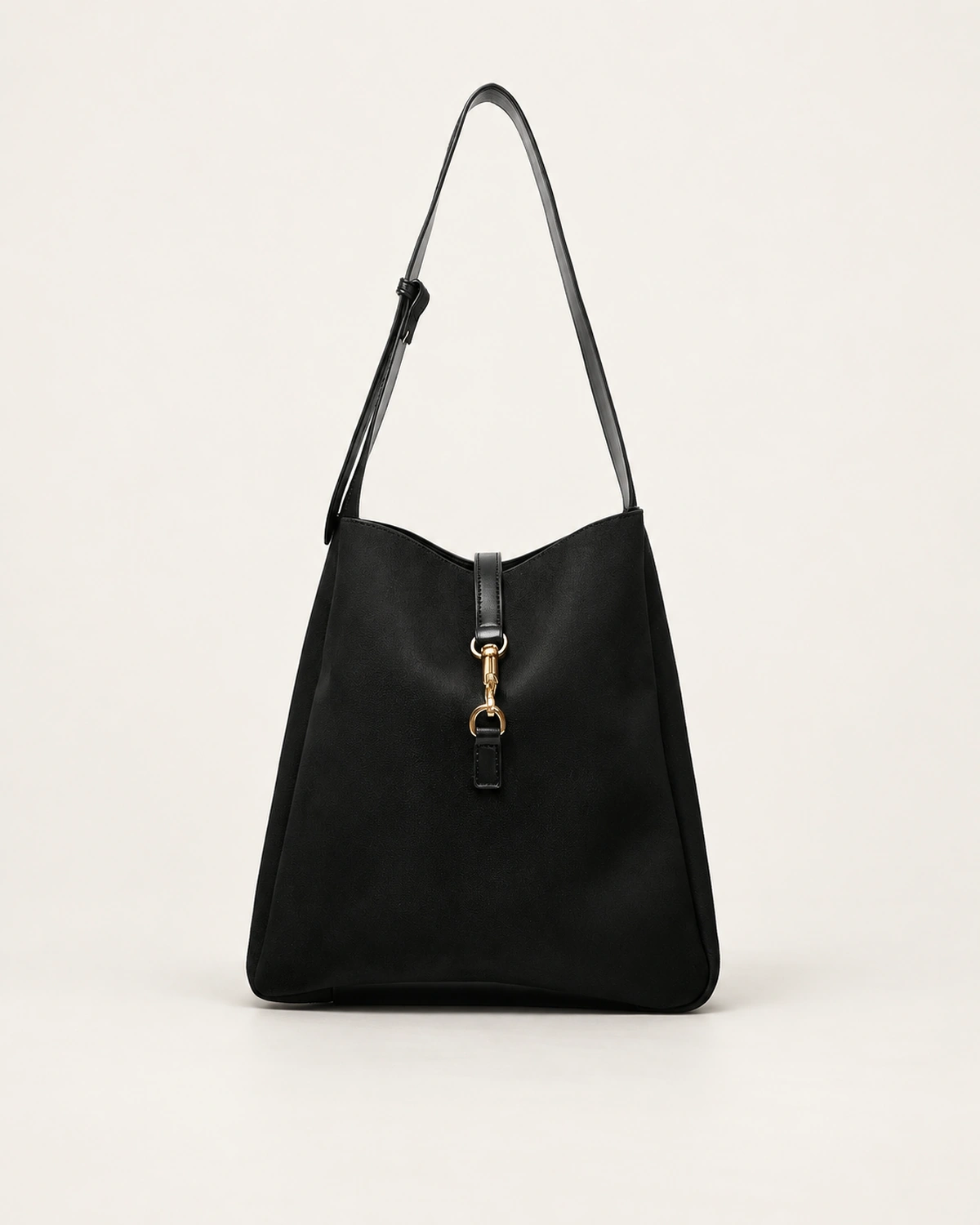 Bolsa shoulder bag preta estruturada com fecho de argolas e fivela metálica dourada no solo mineral