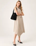Modelo de corpo inteiro com vestido bege e sandálias de salto usando a shoulder bag preta no ombro