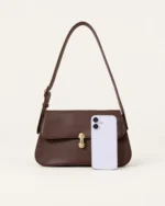 Bolsa tiracolo Café em couro liso e smartphone de referência de proporção.