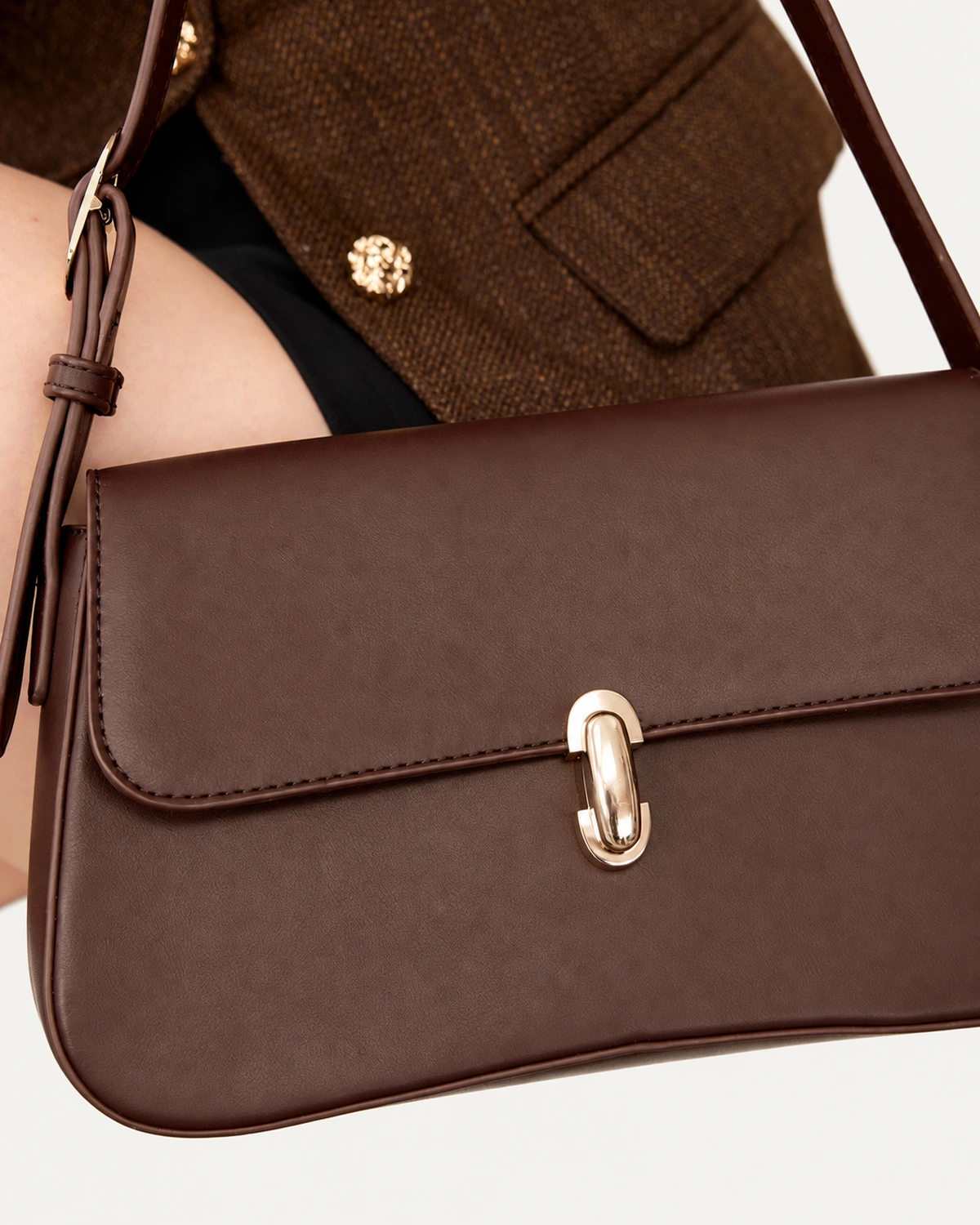 Close da bolsa tiracolo Café e alça regulável em composição com blazer.