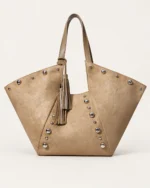 Bolsa tote em suede marrom conhaque em vista frontal no solo mineral destacando silhueta alada e rebites