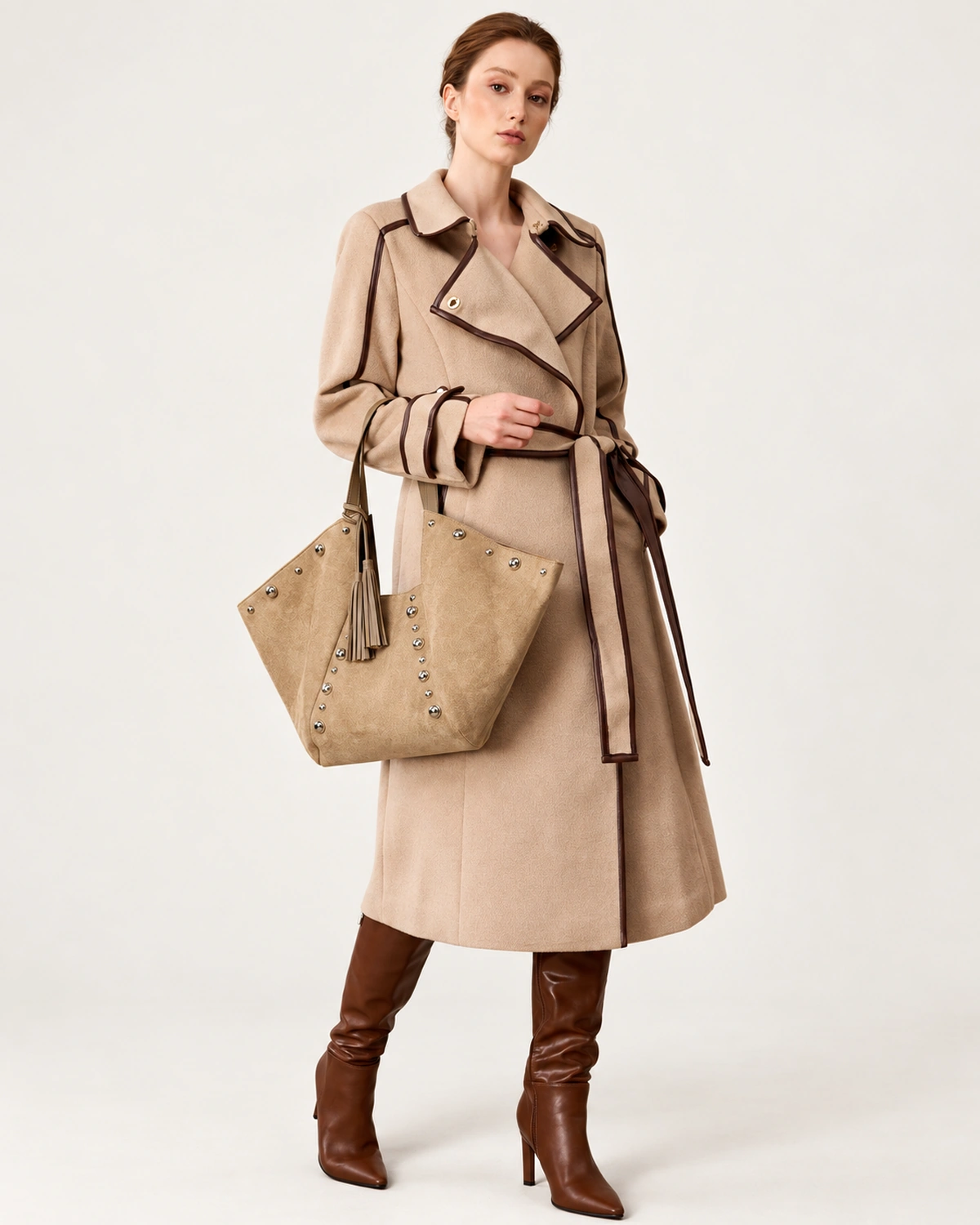 Modelo de corpo inteiro em look elegante de inverno segurando a bolsa tote em suede no antebraço