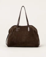 Vista simétrica da bolsa tote bowling marrom em suede no solo mineral
