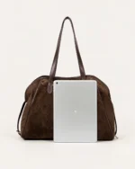 Bolsa tote bowling em suede marrom chocolate com debrum em couro café em vista três quartos no solo mineral