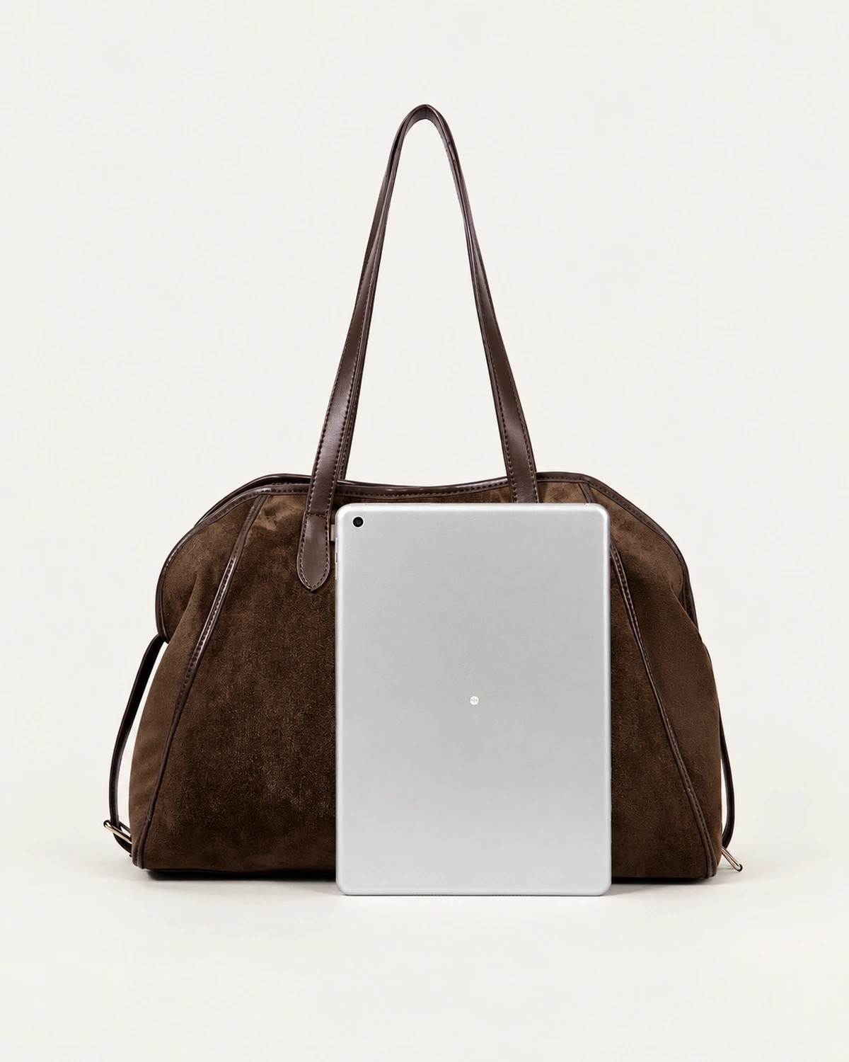 Bolsa tote bowling em suede marrom chocolate com debrum em couro café em vista três quartos no solo mineral