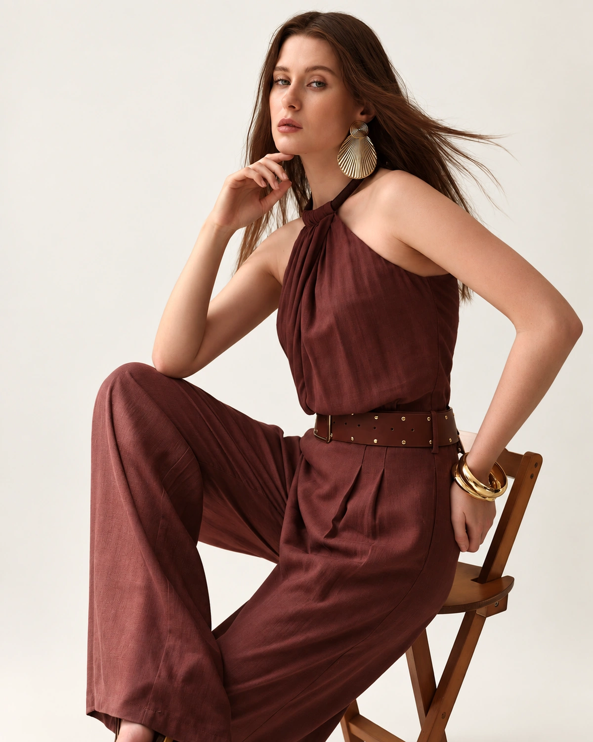 Macacão pantalona em linho com gola halter café — editorial cadeira