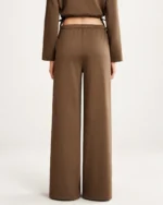 Vista posterior da modelo vestindo calça pantalona fluida em estúdio mineral