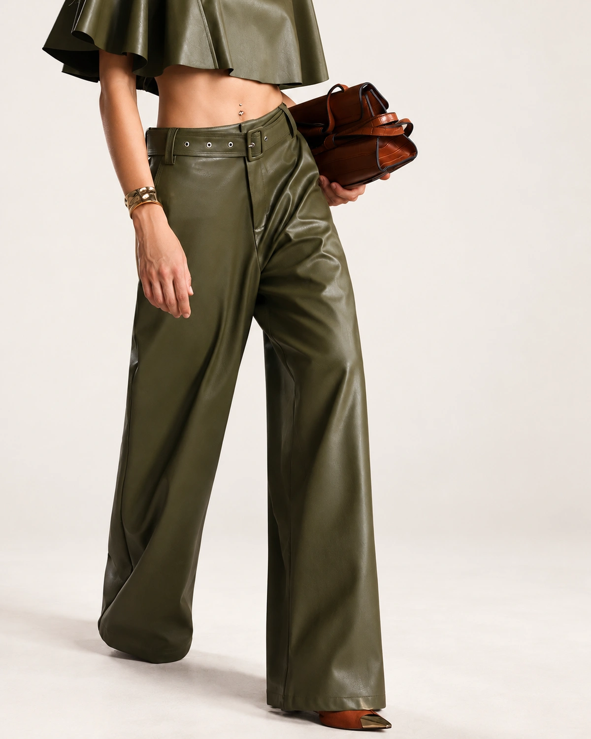Calça pantalona feminina em material sintético PU com cinto fivelado em estúdio mineral.