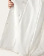 Detalhe da costura interna, forro acetinado e contra-botão de sustentação do vestido blazer off-white.
