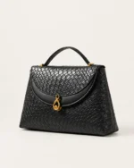 Bolsa Satchel Tressê preta em perspectiva angular destacando o volume estruturado.