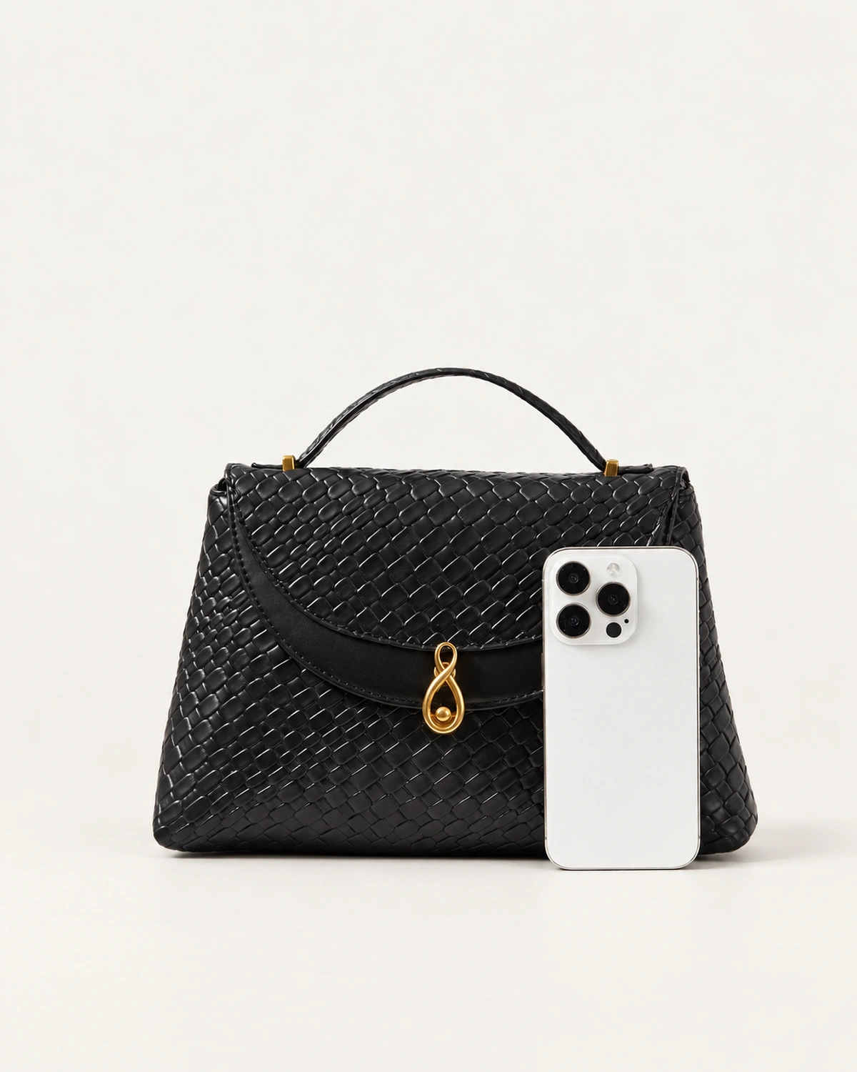 Comparativo de escala da Bolsa Satchel Estruturada preta ao lado de smartphone.