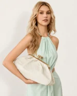 Modelo segurando a Bolsa Clutch Retrô com Fecho Kisslock bege fendi sob o braço.