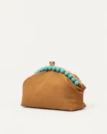 Bolsa clutch marrom em ângulo três quartos sobre fundo mineral neutro