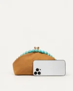 Comparativo de proporção da bolsa clutch marrom com smartphone de escala em estúdio mineral