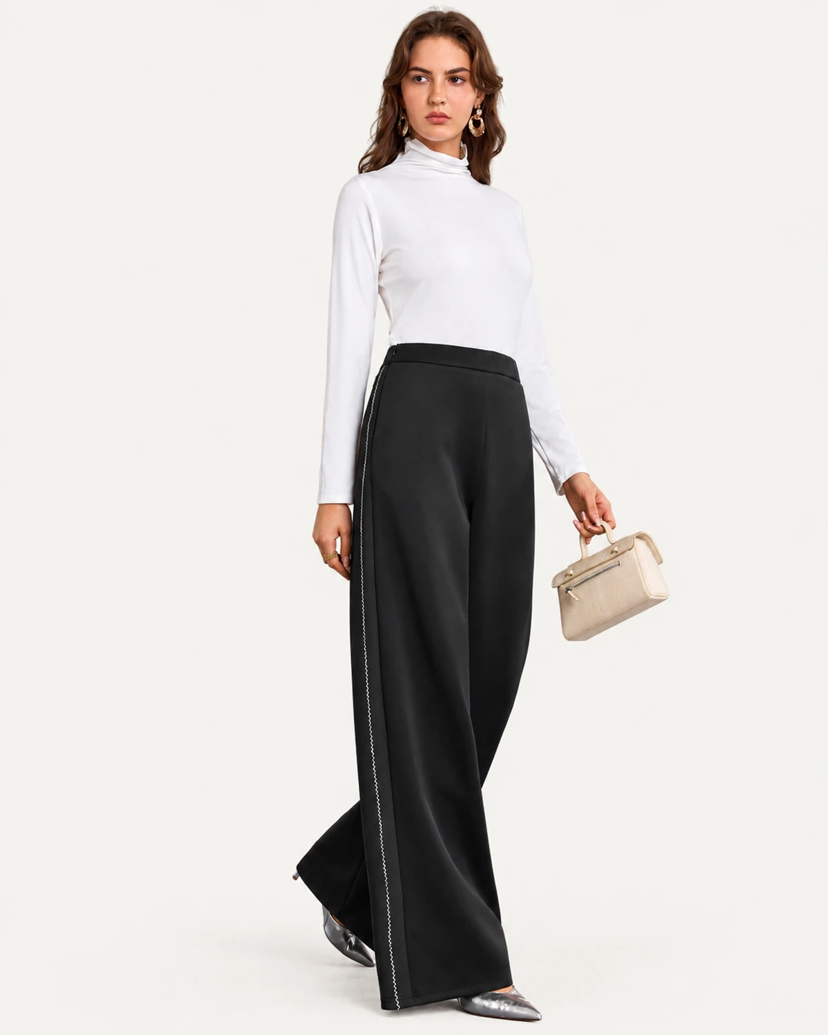 Modelo em pé de corpo inteiro vestindo calça pantalona preta com detalhe lateral contrastante branco em zigue-zague