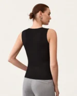 Modelo vestindo regata slim fit com gola redonda fechada na cor Noir em estúdio.