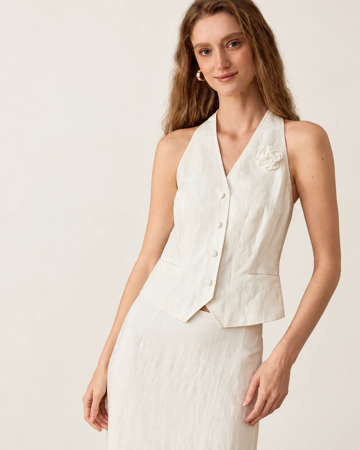 Plano médio da modelo exibindo silhueta elegante do conjunto em linho off-white.