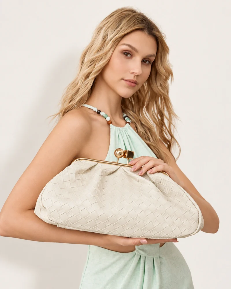 Bolsa Clutch Retrô com Fecho Kisslock em tom bege fendi segurada pela modelo.