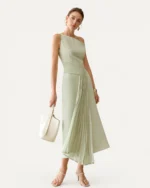 Vestido midi assimétrico com pregas verde-menta visto de frente em modelo