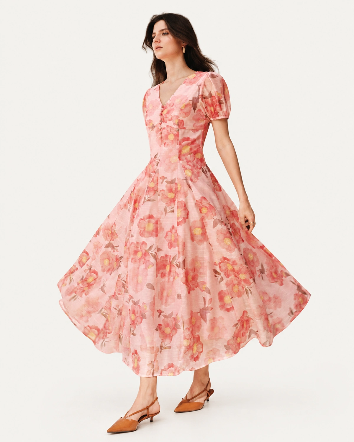 Modelo em movimento com vestido midi floral rosa blush e saia rodada ampla
