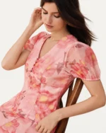 Plano médio do vestido midi floral rosa blush destacando mangas curtas bufantes e decote V