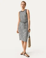 Vestido midi listrado preto e branco com cinto fino visto de frente em modelo
