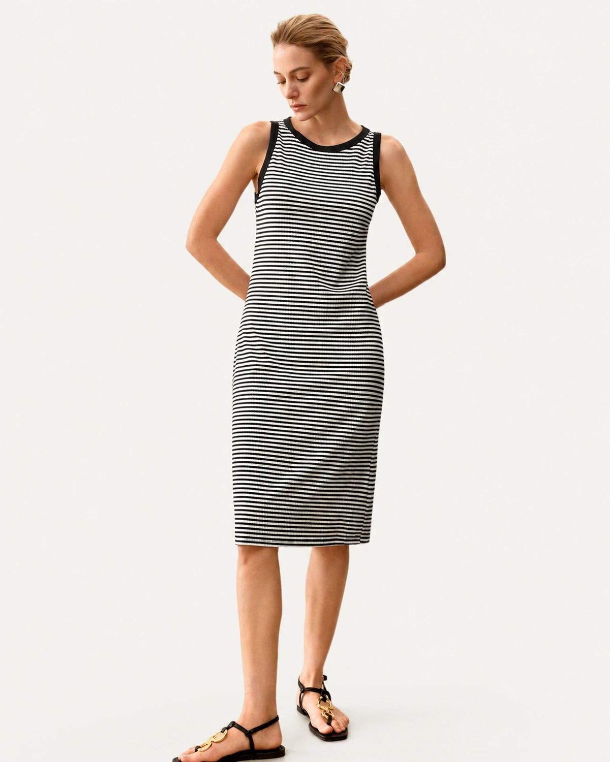 Vestido midi listrado preto e branco usado solto sem cinto em modelo de frente
