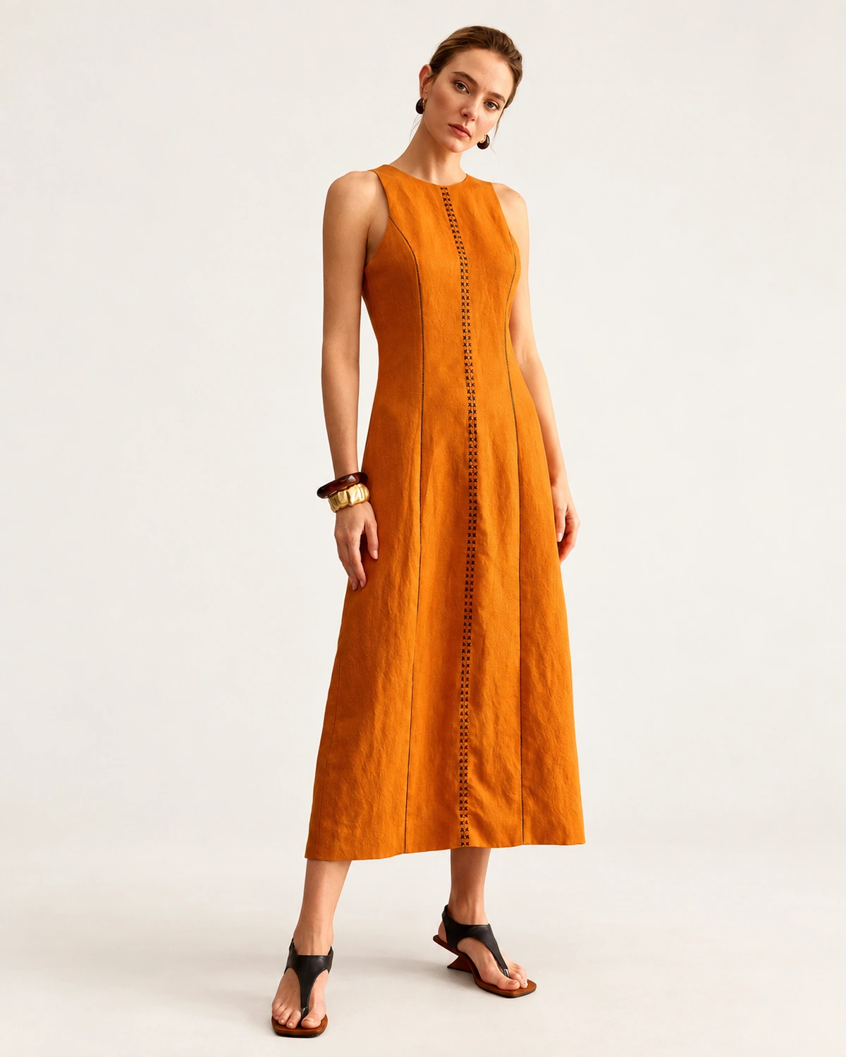 Modelo de corpo inteiro vestindo vestido midi em linho misto com bordado inglês na cor Terracota Solar.