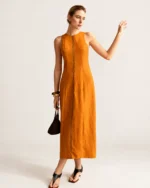 Look completo de corpo inteiro com vestido midi em linho e bolsa de mão na cor Terracota Solar.
