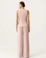 Vista posterior de costas da modelo vestindo o conjunto de alfaiataria rosa blush em estúdio mineral
