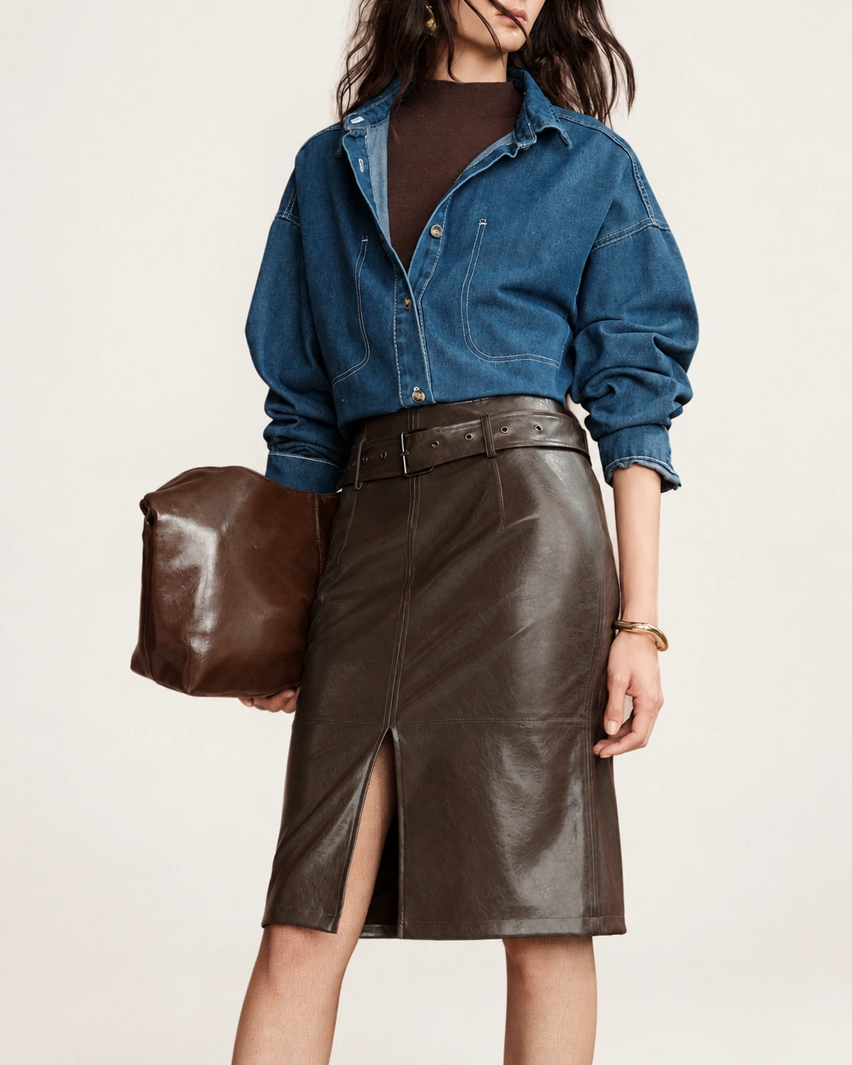 Plano americano da modelo vestindo saia de couro marrom com clutch em estúdio mineral