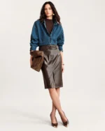 Plano inteiro da modelo vestindo look completo com saia de couro marrom em estúdio mineral