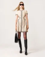 Plano inteiro da modelo vestindo vestido curto damasco com bolsa em estúdio mineral